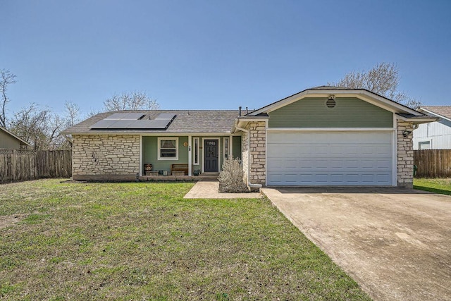 ranch-style house featuring solar panels, a front lawn, fence, stone siding, and driveway