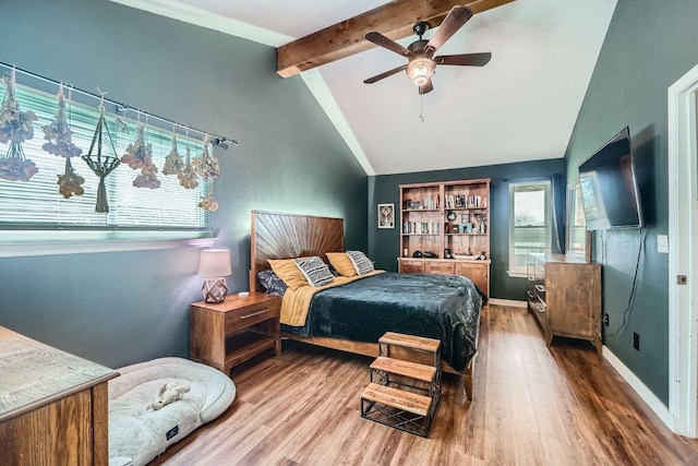 bedroom featuring ceiling fan, lofted ceiling with beams, baseboards, and wood finished floors