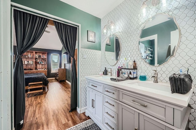 full bathroom with a sink, ensuite bath, and wallpapered walls