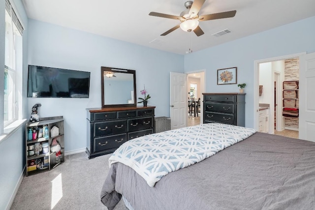 carpeted bedroom featuring visible vents, connected bathroom, a ceiling fan, and baseboards