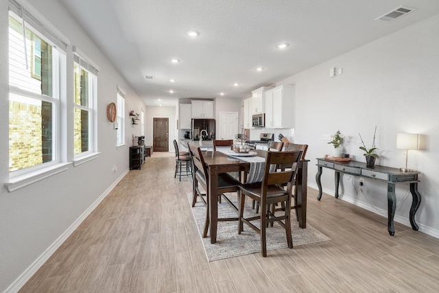 dining area with visible vents, plenty of natural light, and light wood-style floors