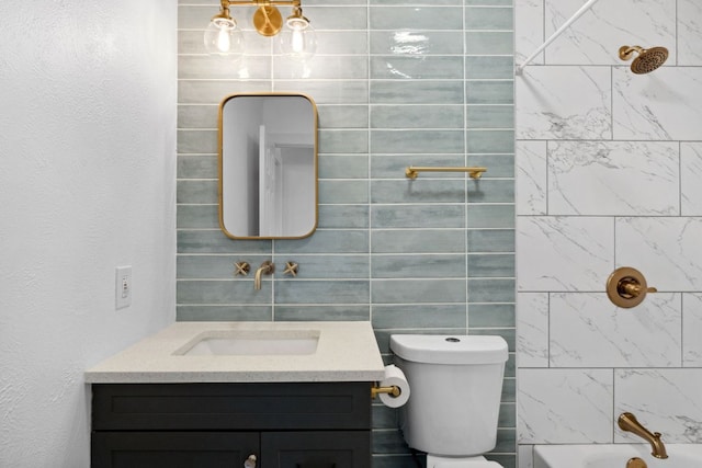 full bath featuring vanity, shower / bathing tub combination, toilet, and tile walls