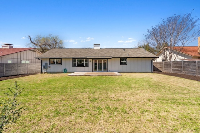 back of house featuring a yard, a fenced backyard, french doors, a patio area, and board and batten siding