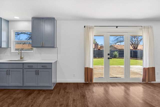 entryway with dark wood finished floors, recessed lighting, baseboards, and a sink