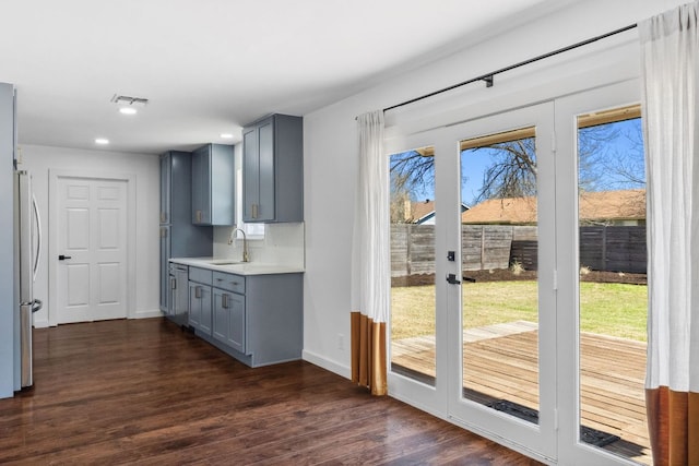 doorway with visible vents, baseboards, dark wood finished floors, recessed lighting, and a sink