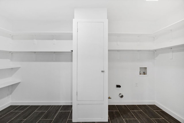 laundry area with laundry area, hookup for a washing machine, baseboards, and wood finish floors