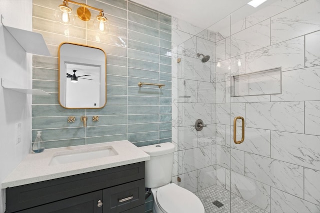 bathroom featuring vanity, tile walls, toilet, and a stall shower