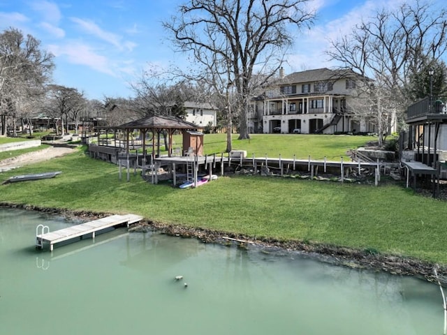 view of dock featuring a gazebo, a yard, and a water view