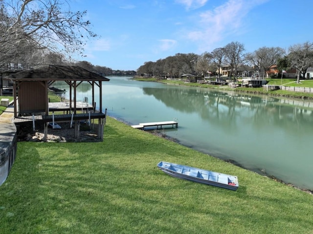 view of dock with a yard and a water view