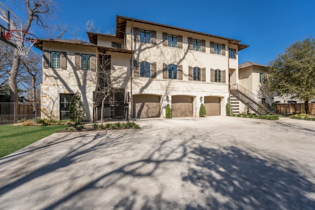 view of front facade featuring stucco siding, concrete driveway, stairs, and a garage