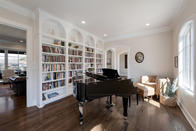 living area featuring crown molding, built in features, recessed lighting, wood finished floors, and arched walkways