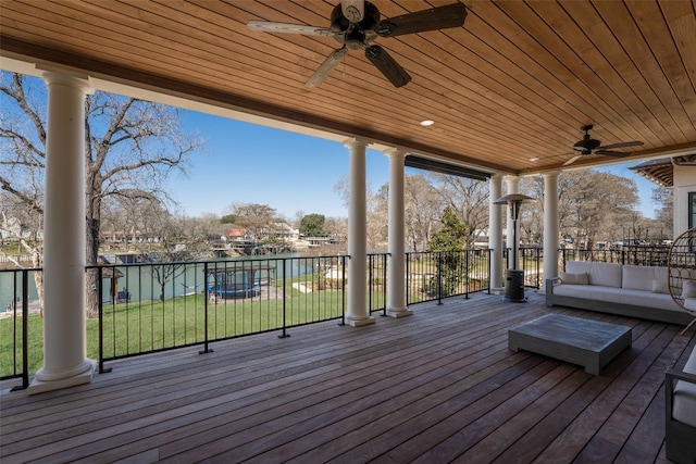 wooden deck with an outdoor hangout area, a yard, and ceiling fan