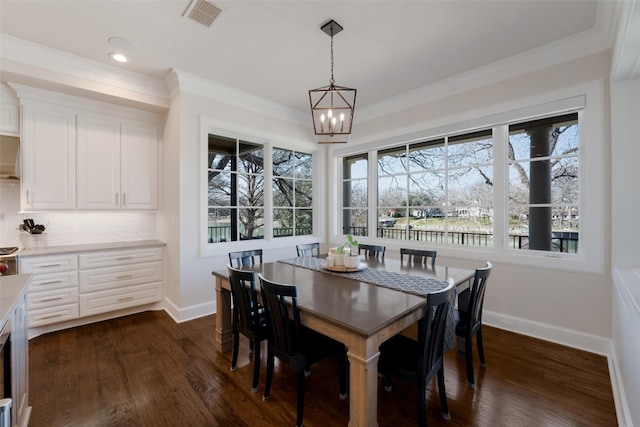 dining room with dark wood finished floors, crown molding, baseboards, and visible vents