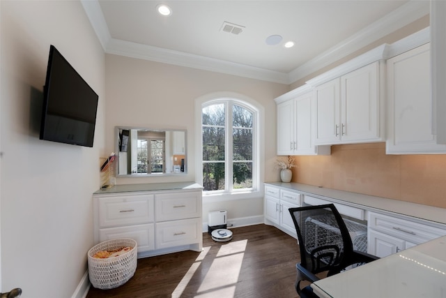 office space featuring baseboards, visible vents, built in study area, dark wood-style flooring, and ornamental molding