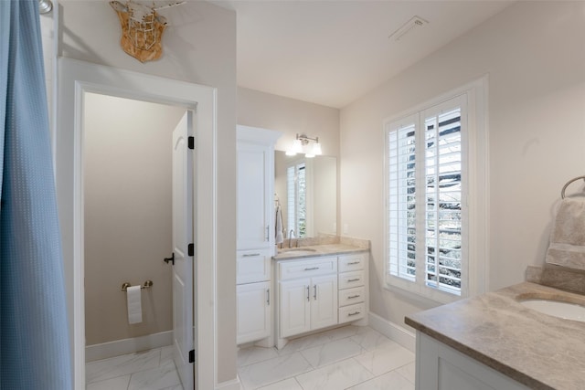 bathroom featuring baseboards, marble finish floor, and vanity