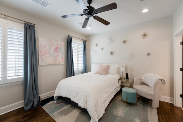 bedroom featuring visible vents, baseboards, and wood finished floors