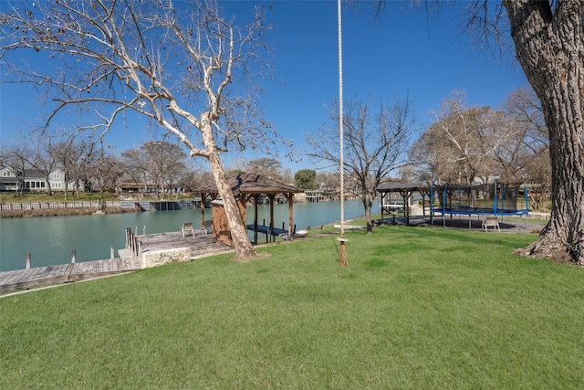 view of yard with a gazebo, a water view, a trampoline, and a dock