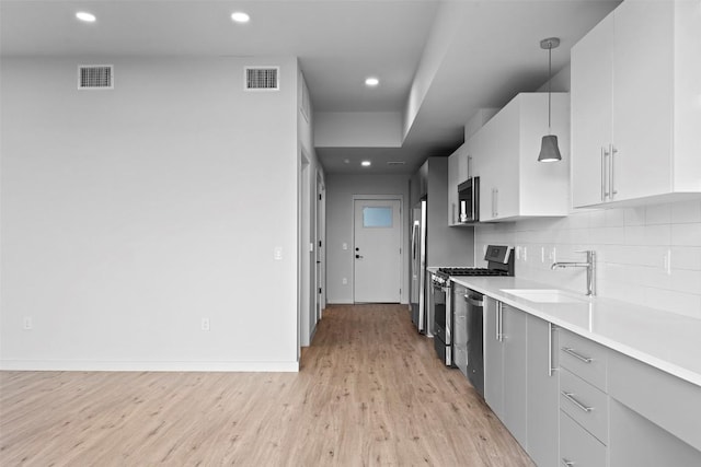 kitchen with backsplash, visible vents, appliances with stainless steel finishes, and a sink