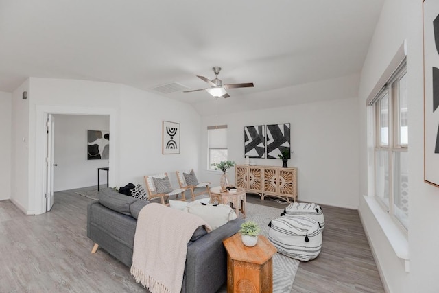 living room featuring a wealth of natural light, visible vents, a ceiling fan, and wood finished floors