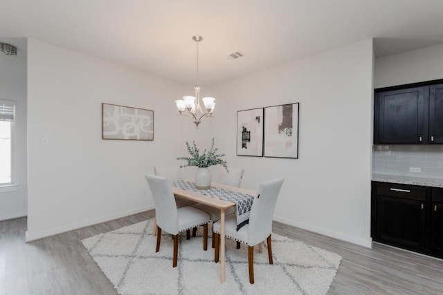 dining area featuring baseboards, a notable chandelier, and light wood-style flooring