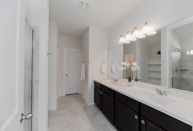 full bath with a sink, visible vents, an enclosed shower, and double vanity