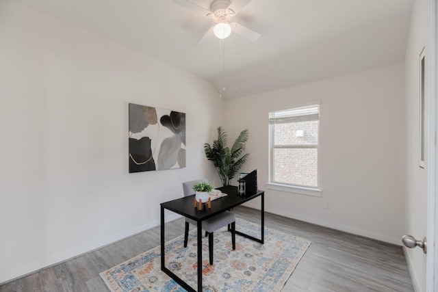 office featuring baseboards, lofted ceiling, wood finished floors, and a ceiling fan