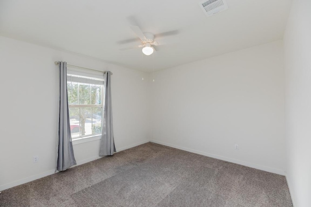 empty room with baseboards, visible vents, a ceiling fan, and carpet