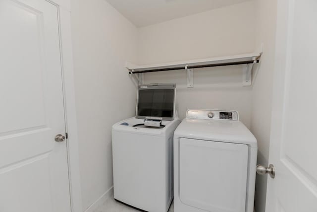 laundry room featuring baseboards, separate washer and dryer, and laundry area