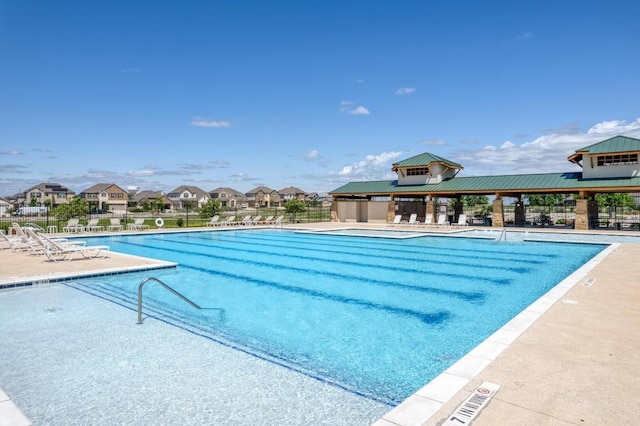 pool with a residential view, a patio, and fence