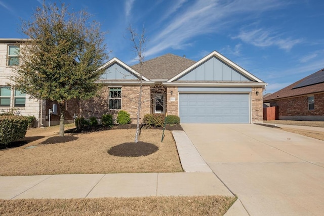 view of front facade with driveway, board and batten siding, roof with shingles, a garage, and brick siding