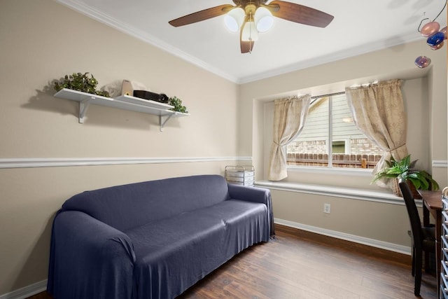 living area with wood finished floors, a ceiling fan, baseboards, and ornamental molding