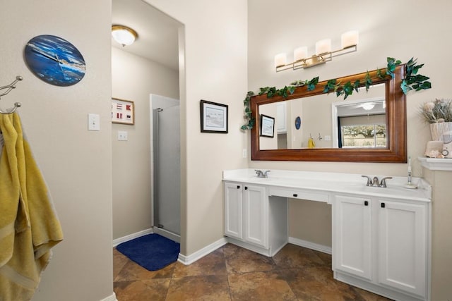 full bathroom with double vanity, baseboards, and a stall shower