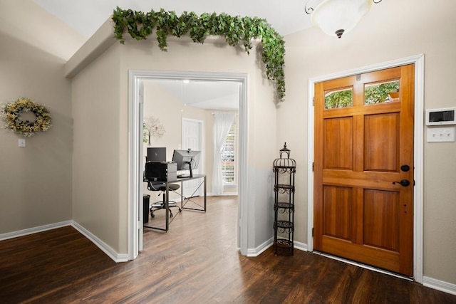 foyer entrance featuring dark wood-style flooring and baseboards
