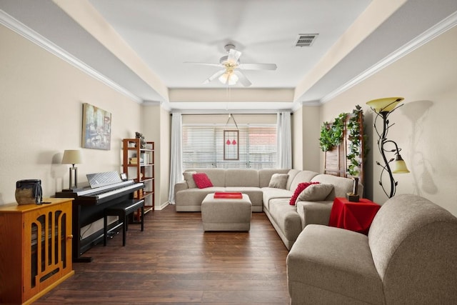 living area with dark wood-style flooring, ornamental molding, a ceiling fan, and visible vents