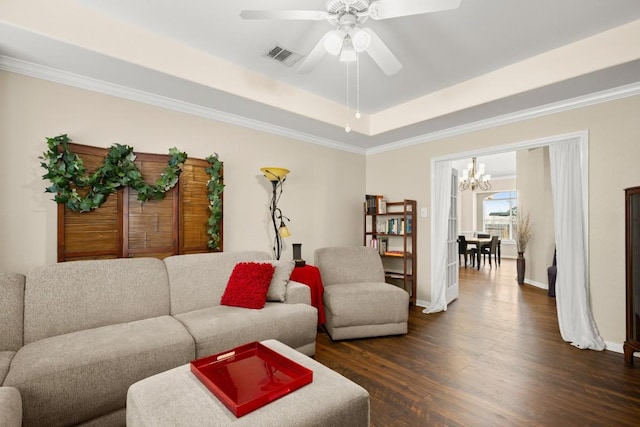 living area featuring visible vents, baseboards, a tray ceiling, ceiling fan with notable chandelier, and dark wood-style floors