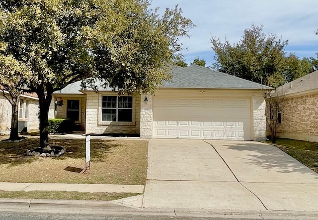 single story home with stone siding, driveway, a shingled roof, and an attached garage