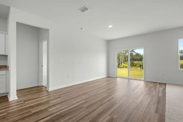 1424 Morris Loop, San Marcos, TX 78666 - unfurnished living room featuring healthy amount of natural light, wood finished floors, baseboards, and recessed lighting