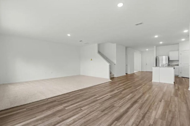 1424 Morris Loop, San Marcos, TX 78666 - unfurnished living room featuring recessed lighting, stairway, and light wood-type flooring