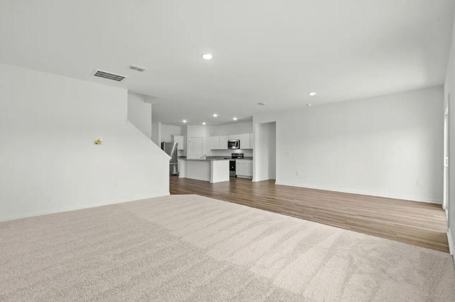 1424 Morris Loop, San Marcos, TX 78666 - unfurnished living room with recessed lighting, dark colored carpet, and dark wood finished floors