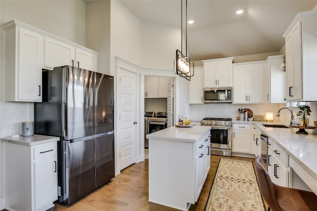 kitchen featuring a sink, tasteful backsplash, appliances with stainless steel finishes, and a center island