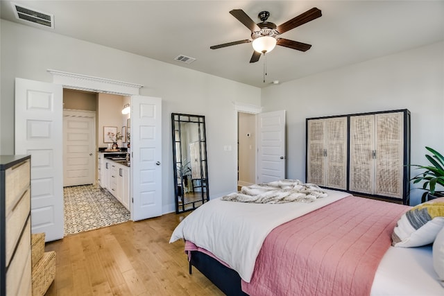 bedroom with visible vents, light wood-style floors, and a ceiling fan