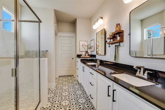 full bath with double vanity, a shower stall, and a sink