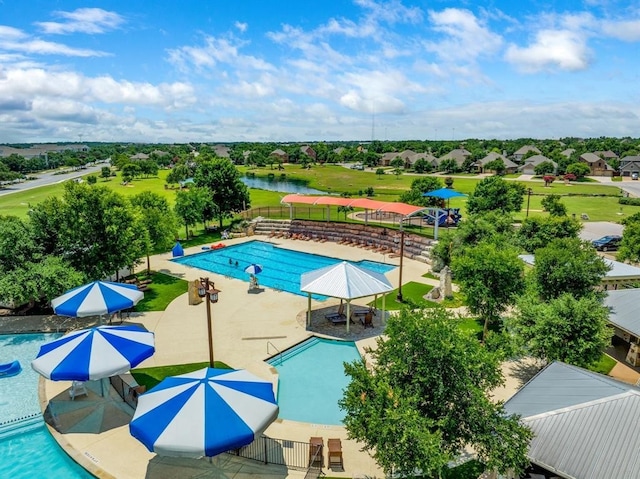 community pool with a gazebo, a patio area, a water view, and fence