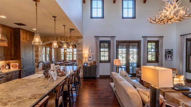 dining area featuring visible vents, dark wood-type flooring, a chandelier, recessed lighting, and a towering ceiling