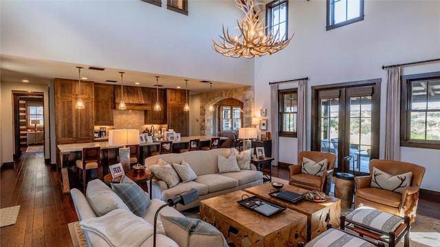 living area with a notable chandelier, plenty of natural light, and dark wood-style flooring