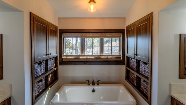 full bathroom featuring a freestanding tub and vanity