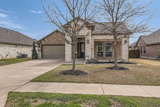 view of front of property with central AC, concrete driveway, stone siding, a garage, and brick siding