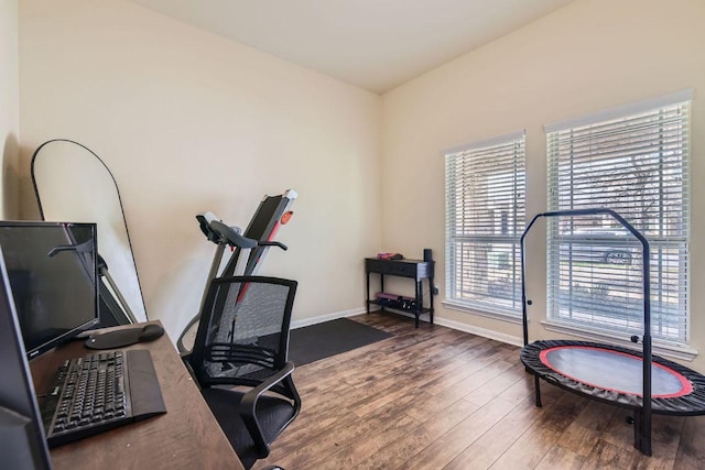 exercise area with baseboards and wood finished floors