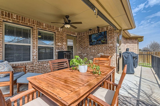 view of patio / terrace with a grill, outdoor dining area, fence, and ceiling fan