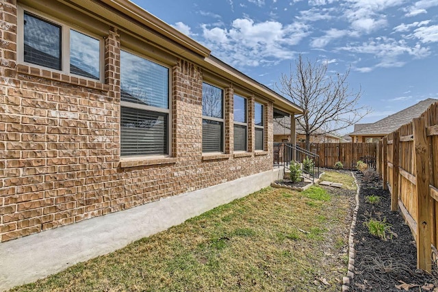 view of home's exterior featuring brick siding and a fenced backyard